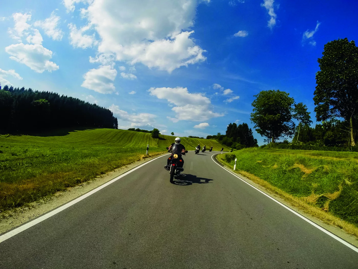 Mehrere Motorräder auf einer weiten Landstraße Mehrere Motorräder auf einer weiten Landstraße